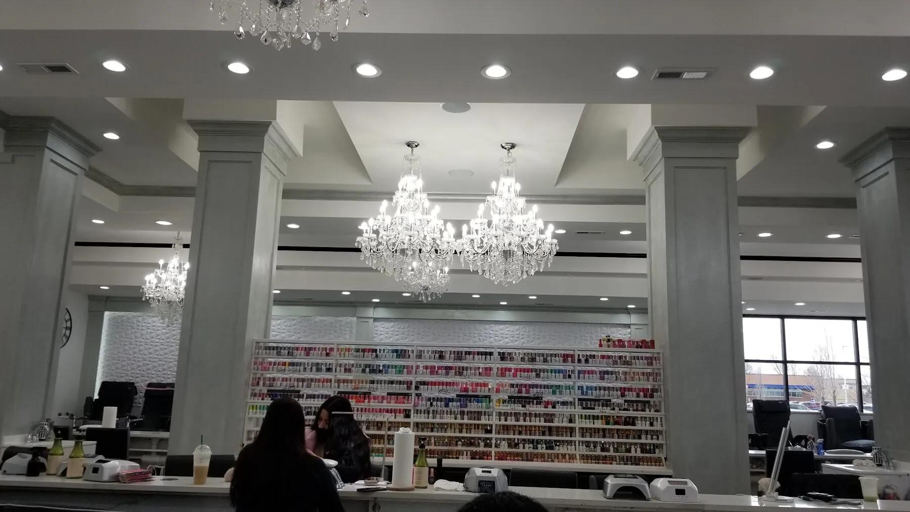 Grand, chandelier-lit main floor and floor-to-ceiling polish wall at Gloss Nail Bar Rockford