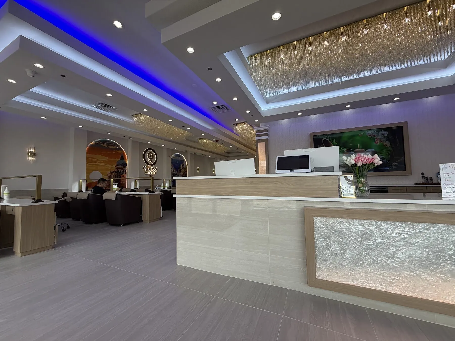 Sweeping blue-lit main hall and reception at Gloss Nail Bar Geneva