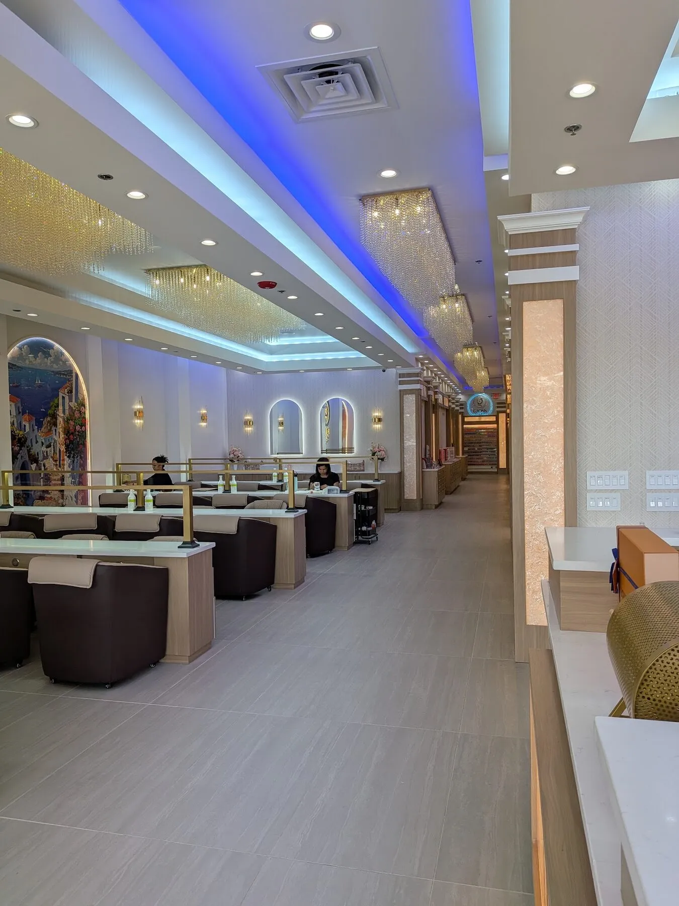 Opulent pedicure hall with an arched Mediterranean mural and ambient light