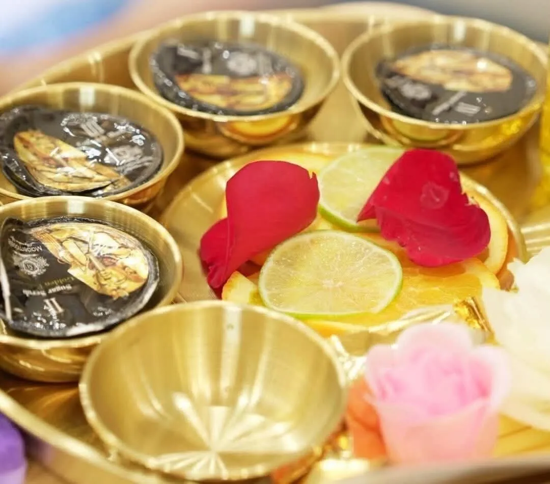 Deluxe pedicure ritual tray of gold bowls with sugar scrubs, fresh citrus and rose petals at Gloss Nail Bar Niles