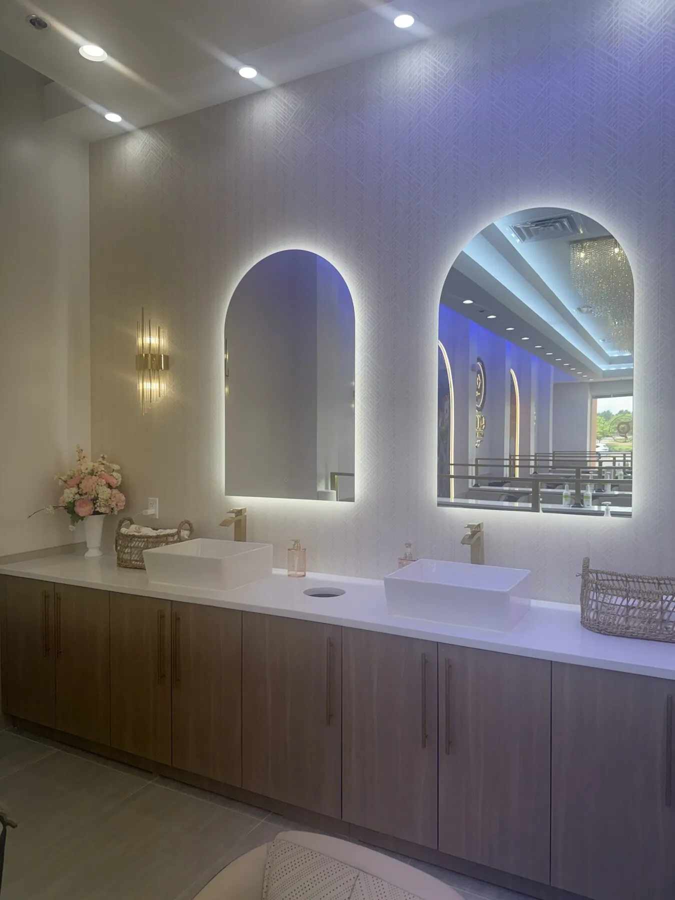 Bright powder room with arched mirrors and fresh florals