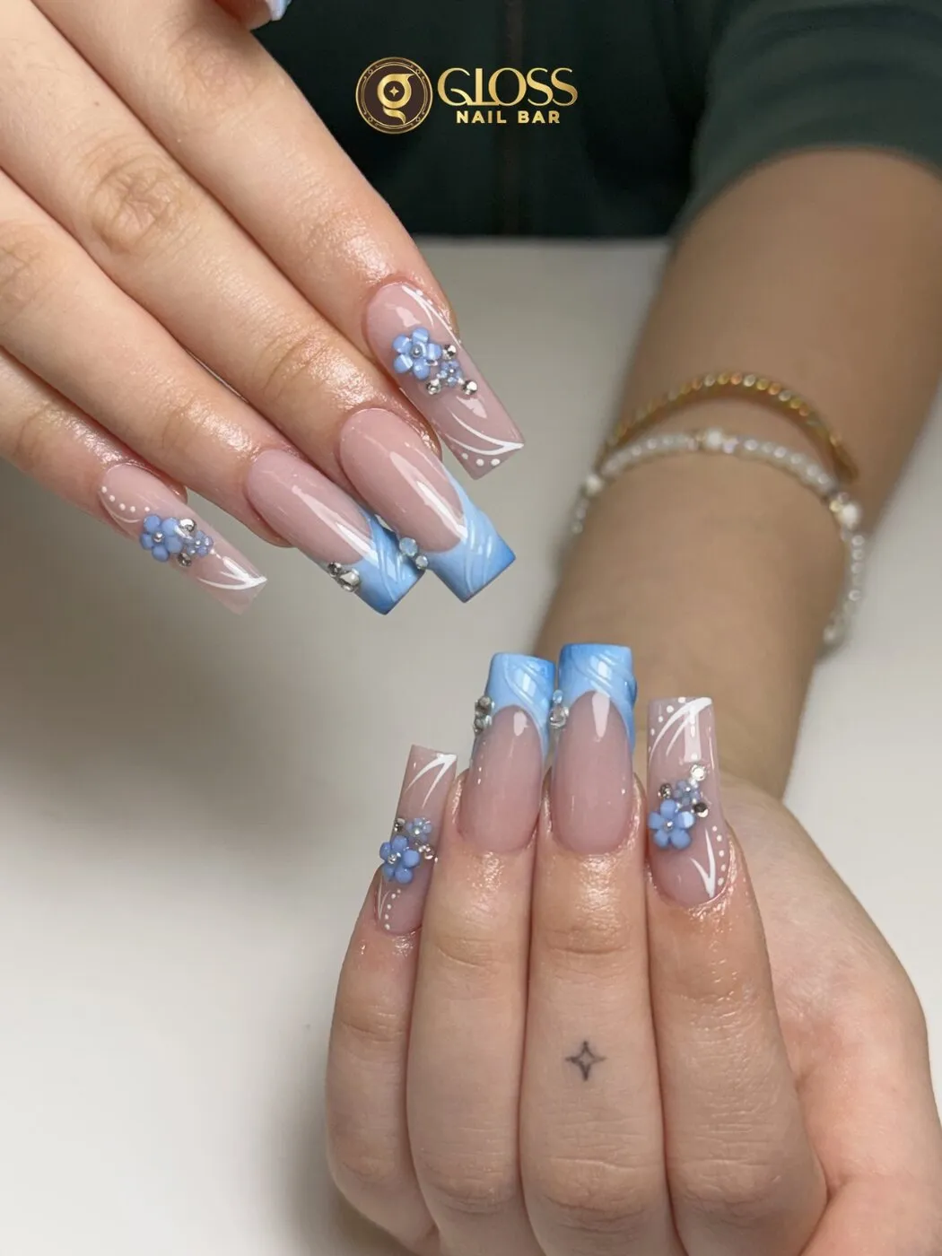 Powder-blue swirl French tips with 3D florals and fine white line work