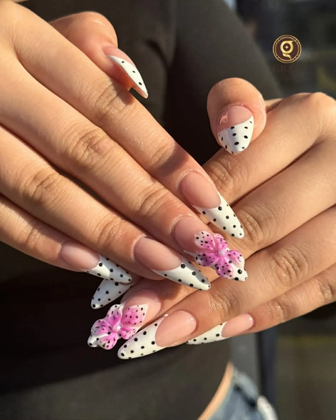 White polka-dot French stiletto nails with hand-painted 3D pink flowers
